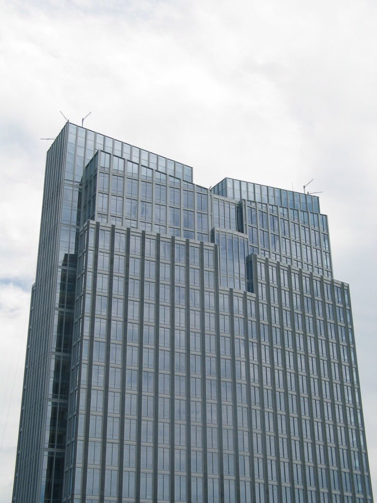 the skyscr with a large glass facade in front of it