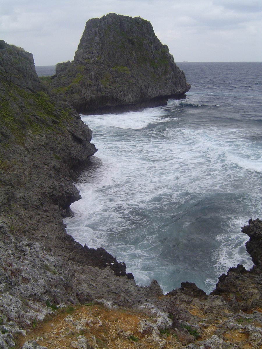 an ocean landscape with rocks on one side and sea water on another