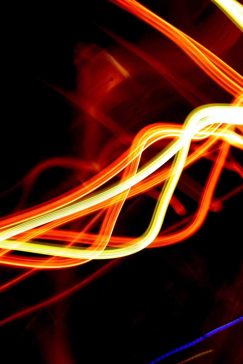 blurry light painting of a black background with red, yellow, and blue lights