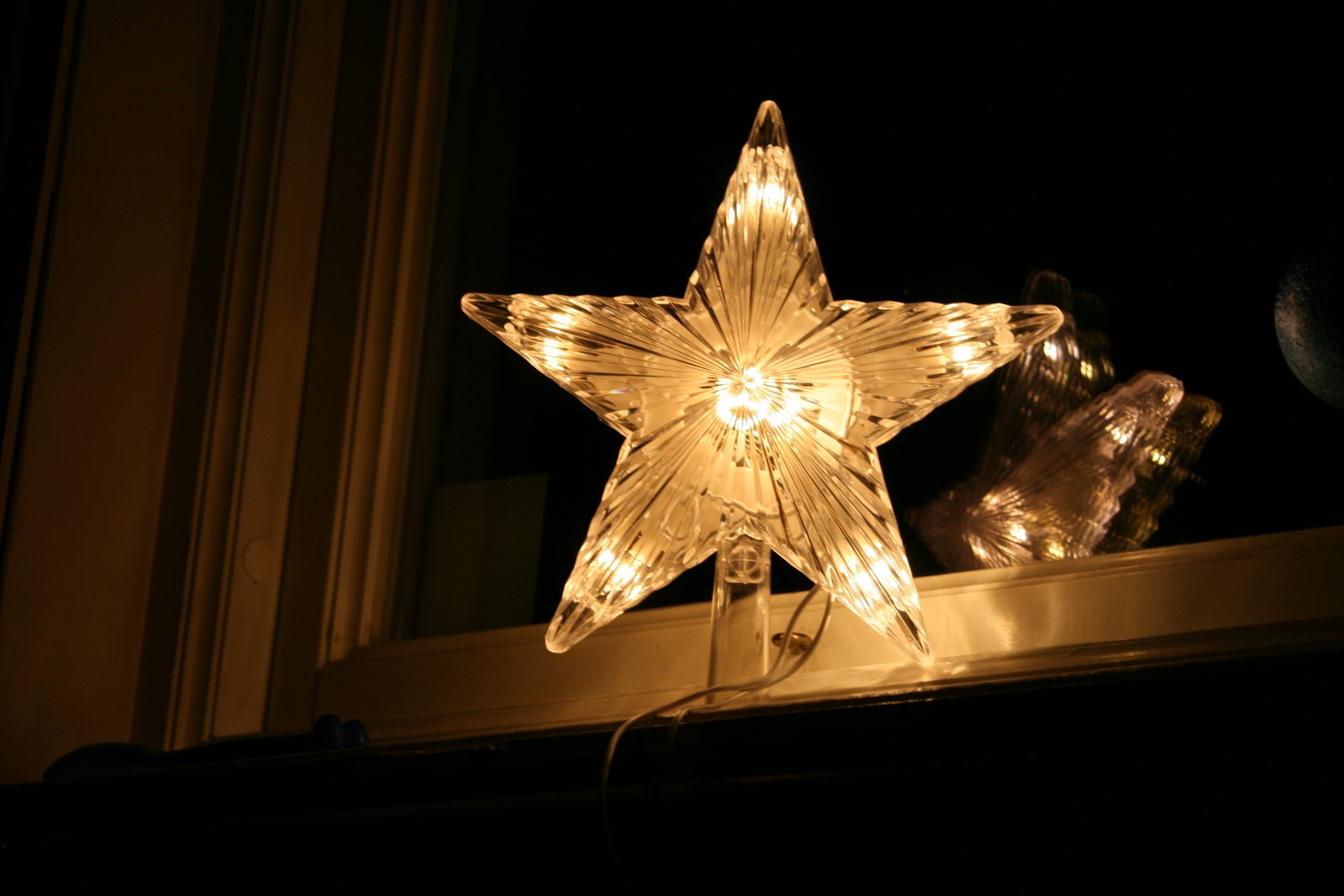 a lighted glass star on the window sill