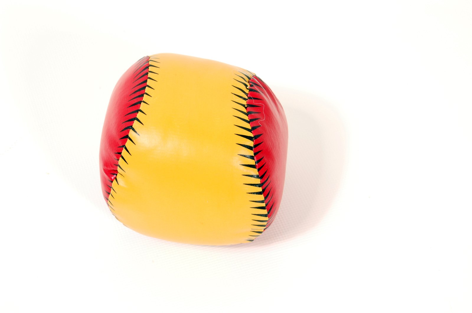 a toy baseball with spikes, laying on a white surface