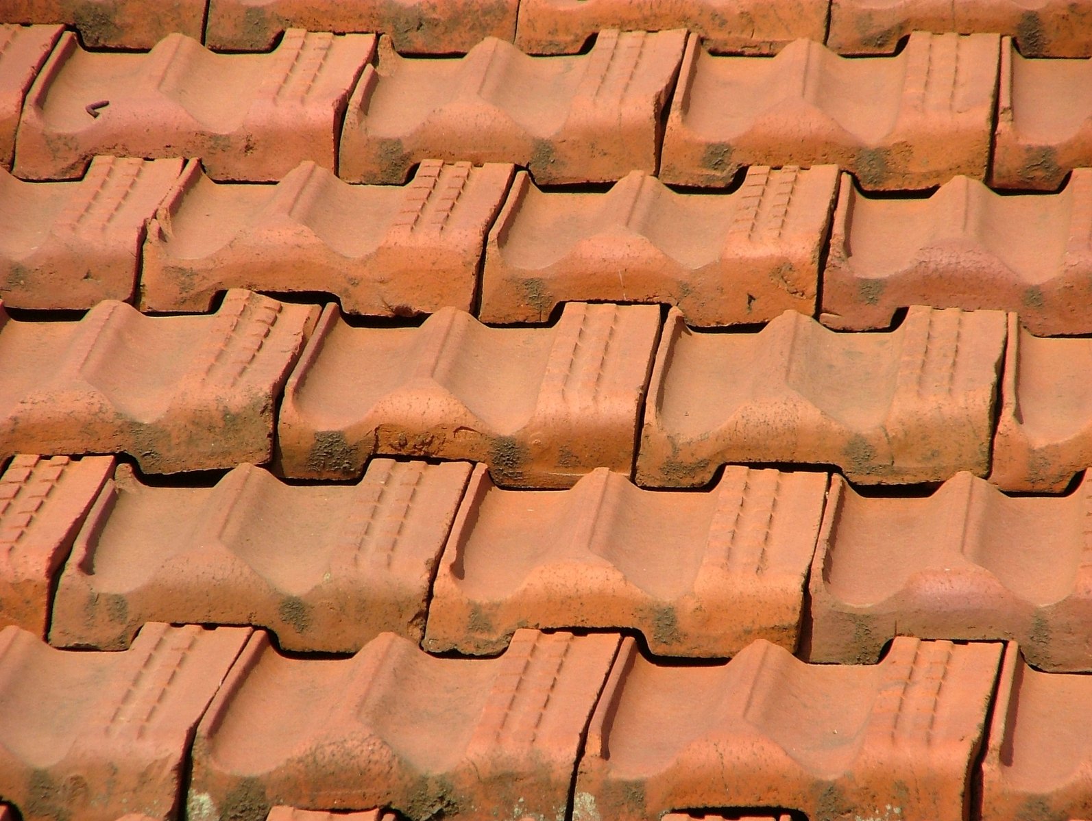 a red clay roof with three rows of gutter roofs