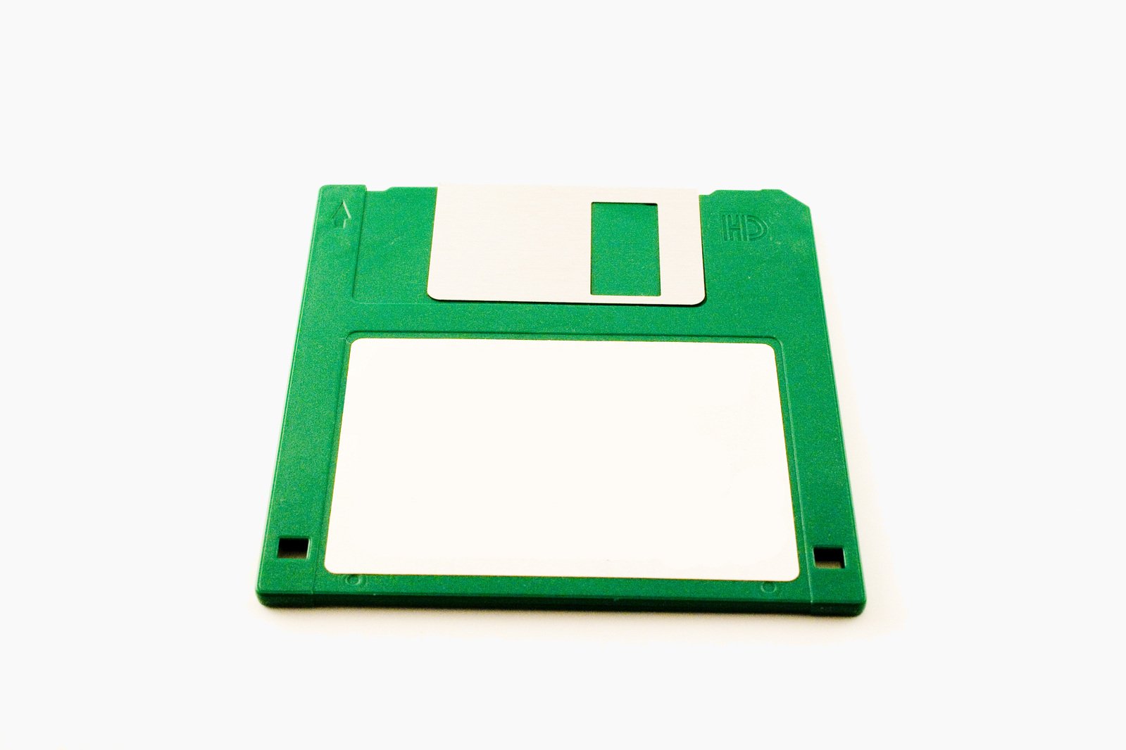 a floppy disk with some white plastic and a blank note pad