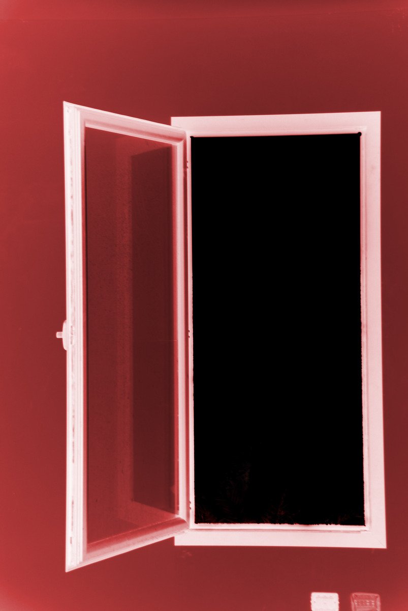 an open window on top of a red wall