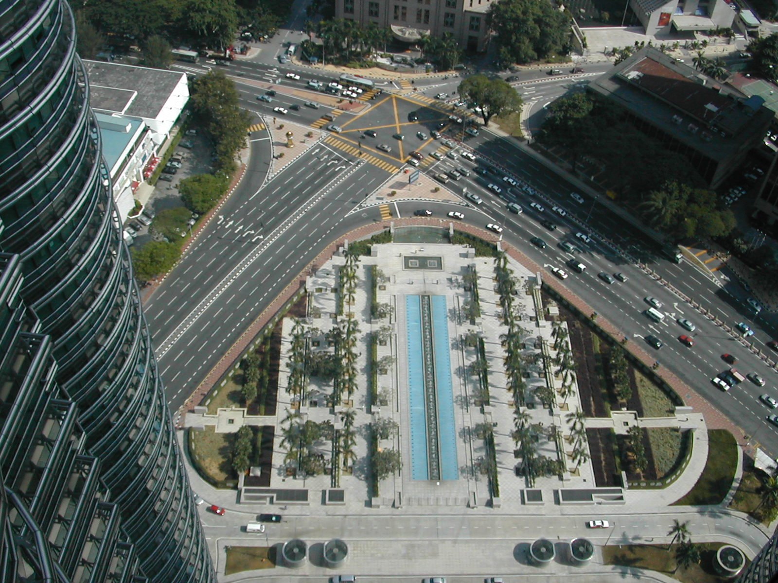 a city street with a fountain next to two buildings