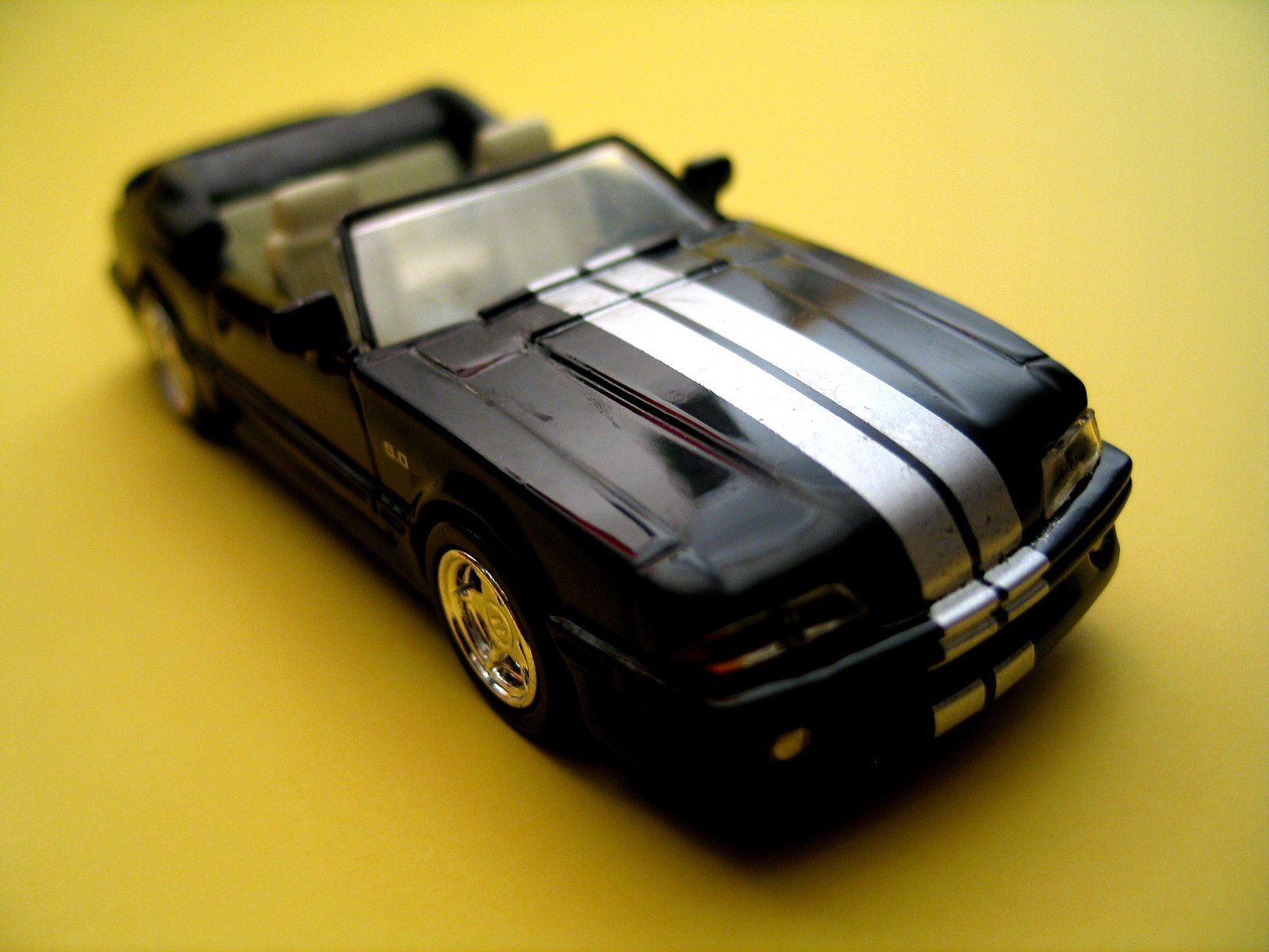 a model of a car with yellow rims and stripes