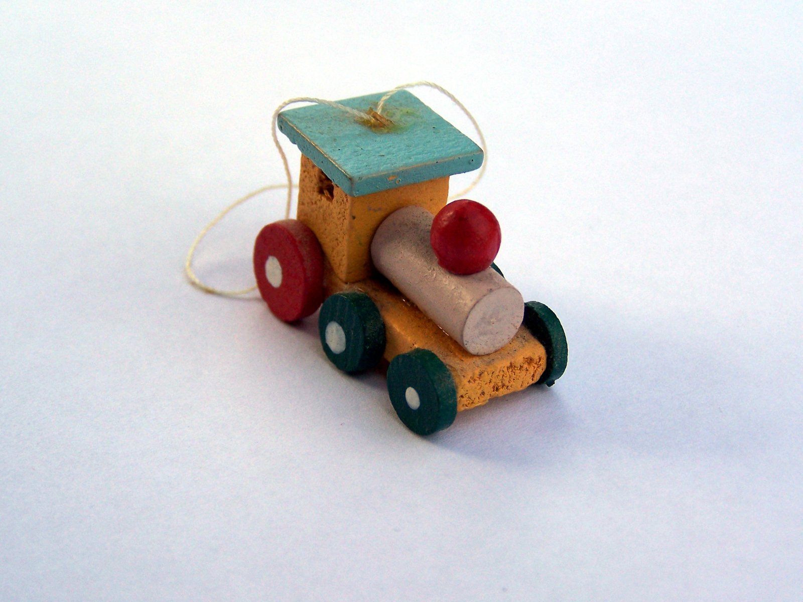 a wooden toy car with red s sits on a white background