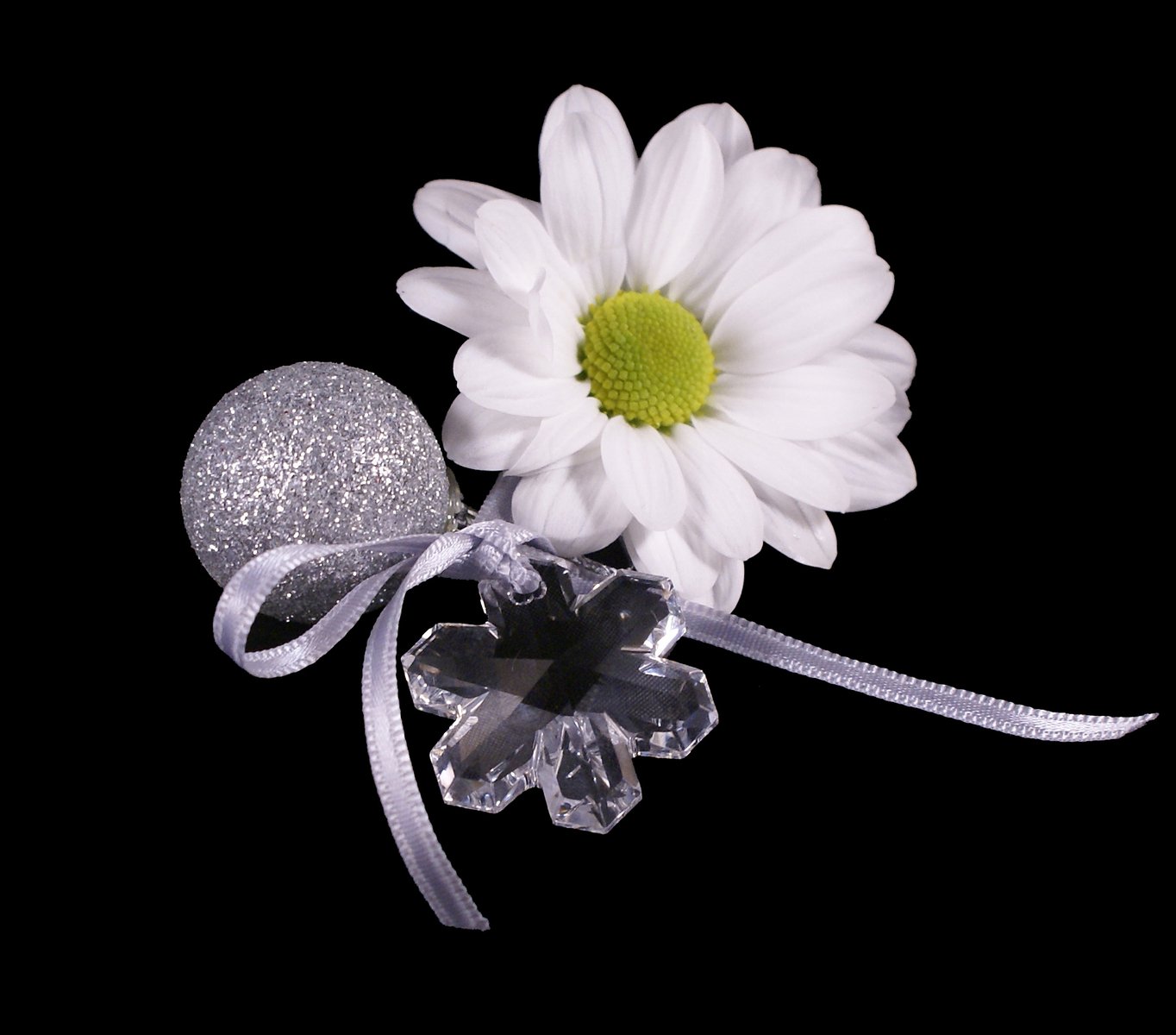 a white flower sitting on top of a piece of ribbon