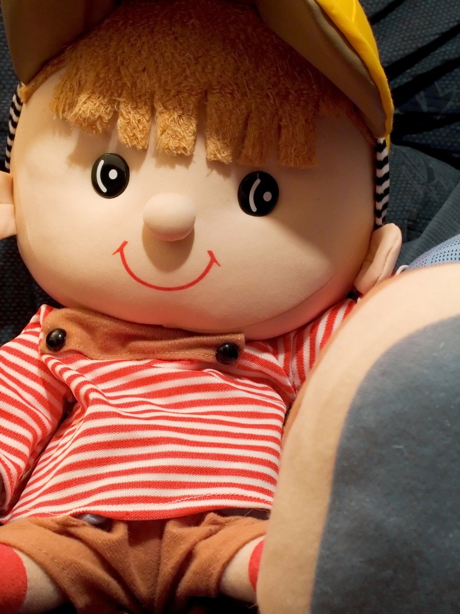 a plush doll wearing a yellow hat and striped shirt