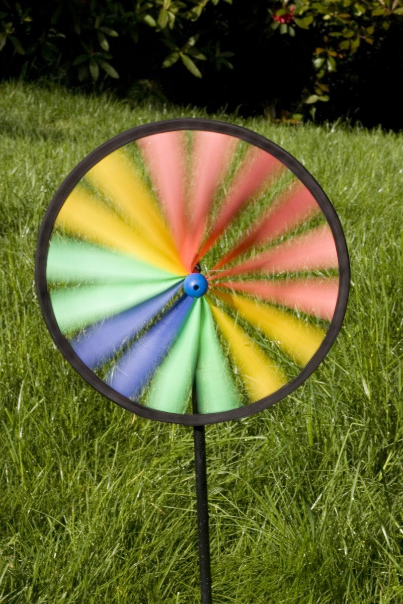 a spinning wheel is standing in the grass
