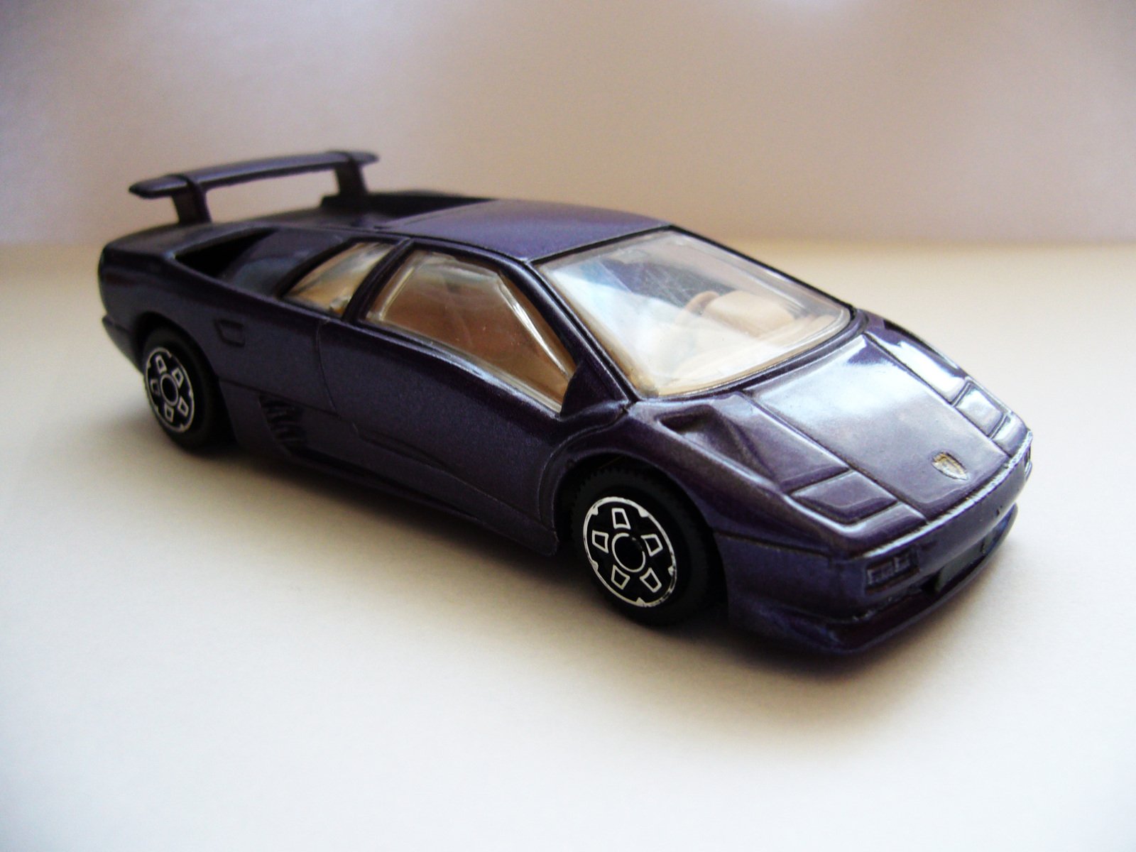 a toy car with a top down sitting on a white surface
