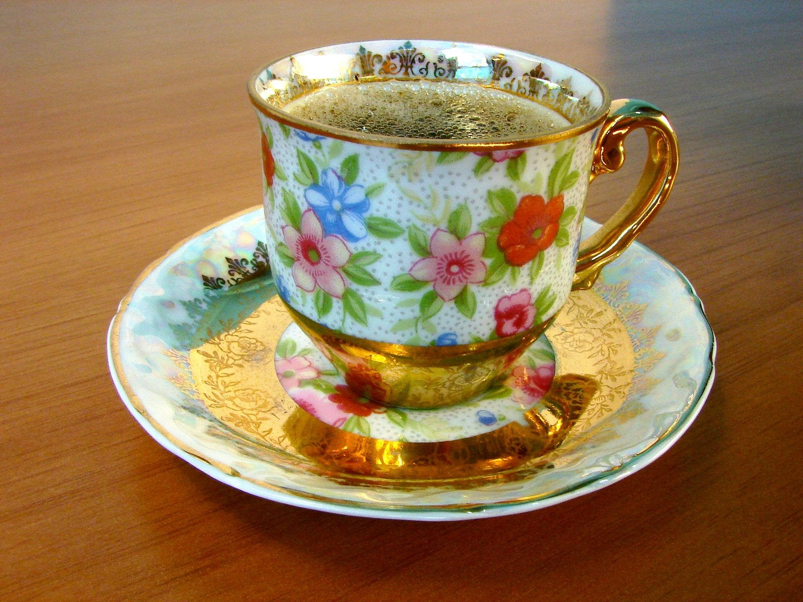 an antique cup and saucer on a wooden table