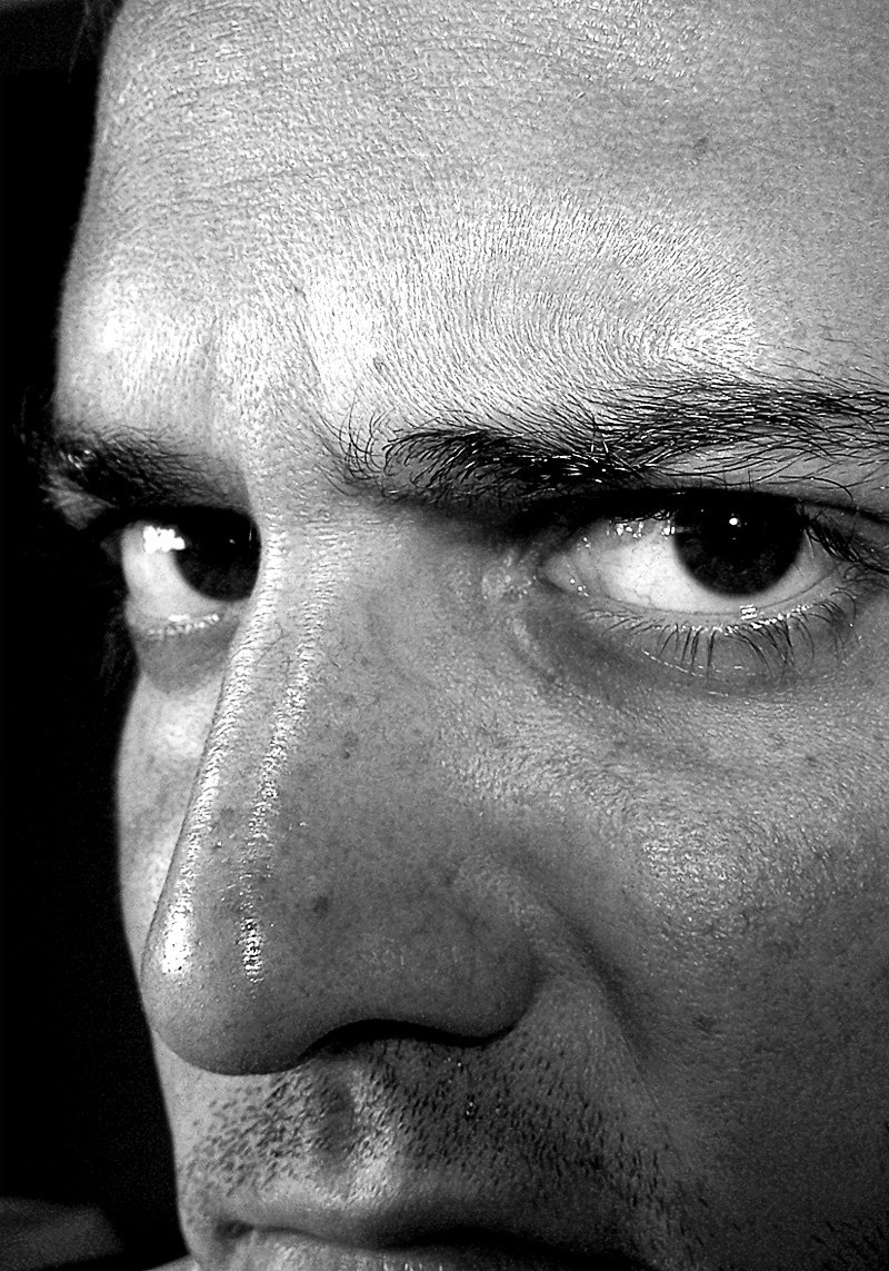 man in black and white pograph of face and upper corner of eyes