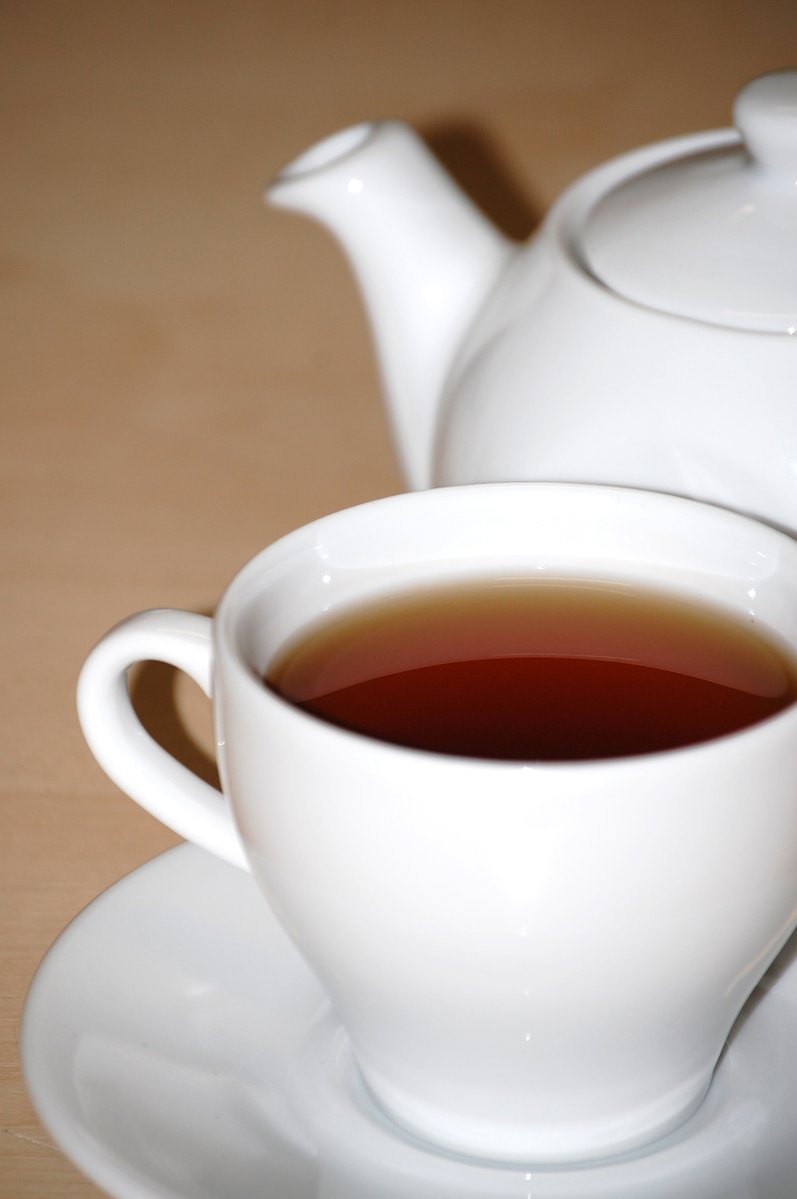 there is a cup of tea sitting next to a cup of coffee