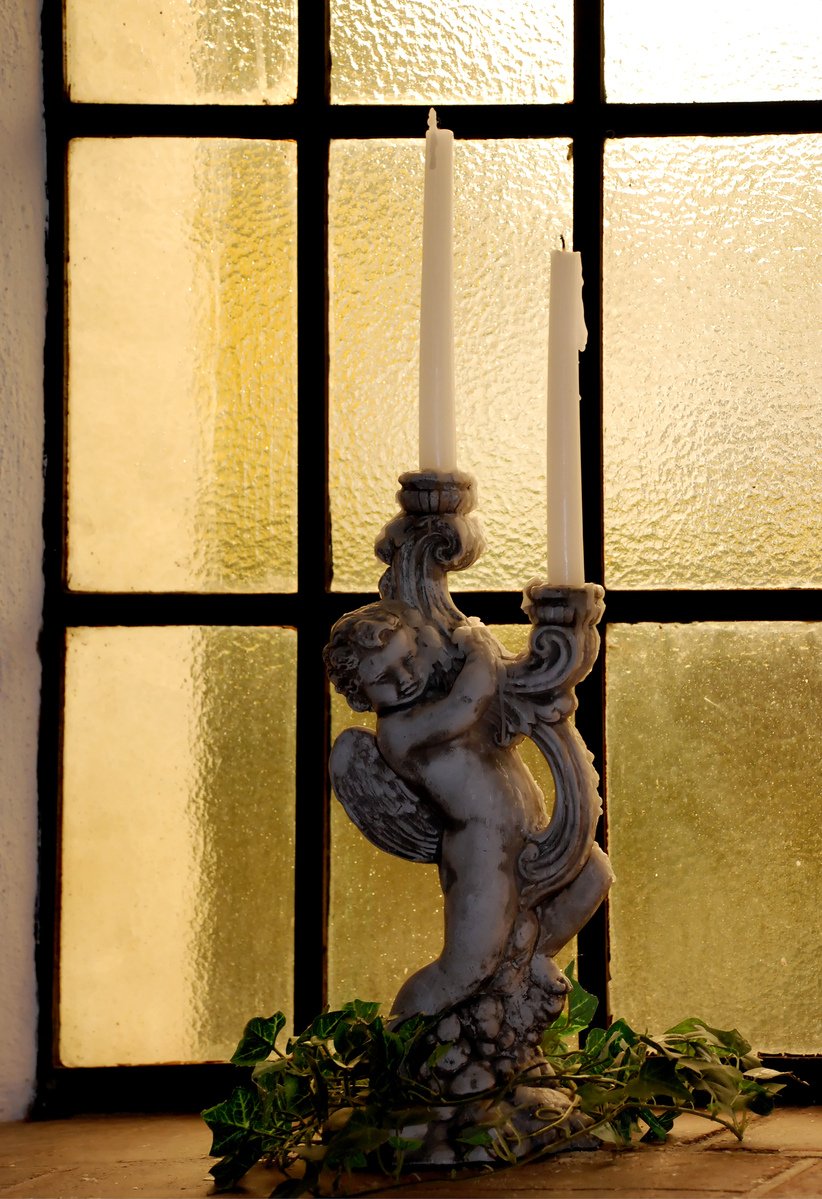 a candle holder and some candles are in front of the window