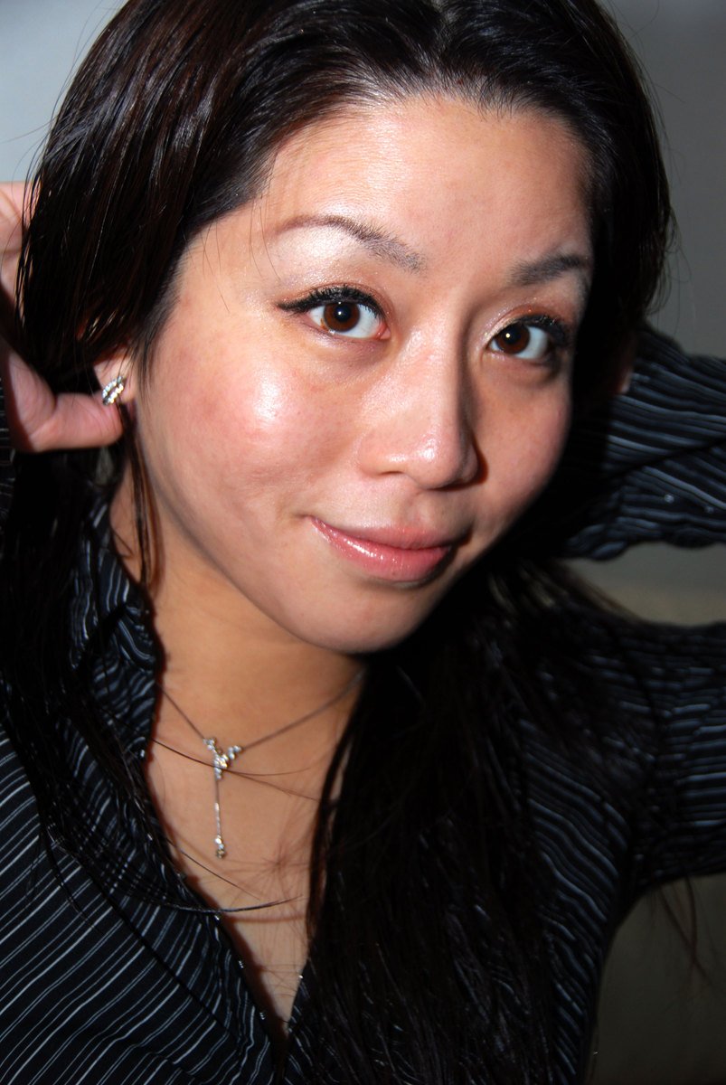 the young woman is wearing earrings and a striped shirt