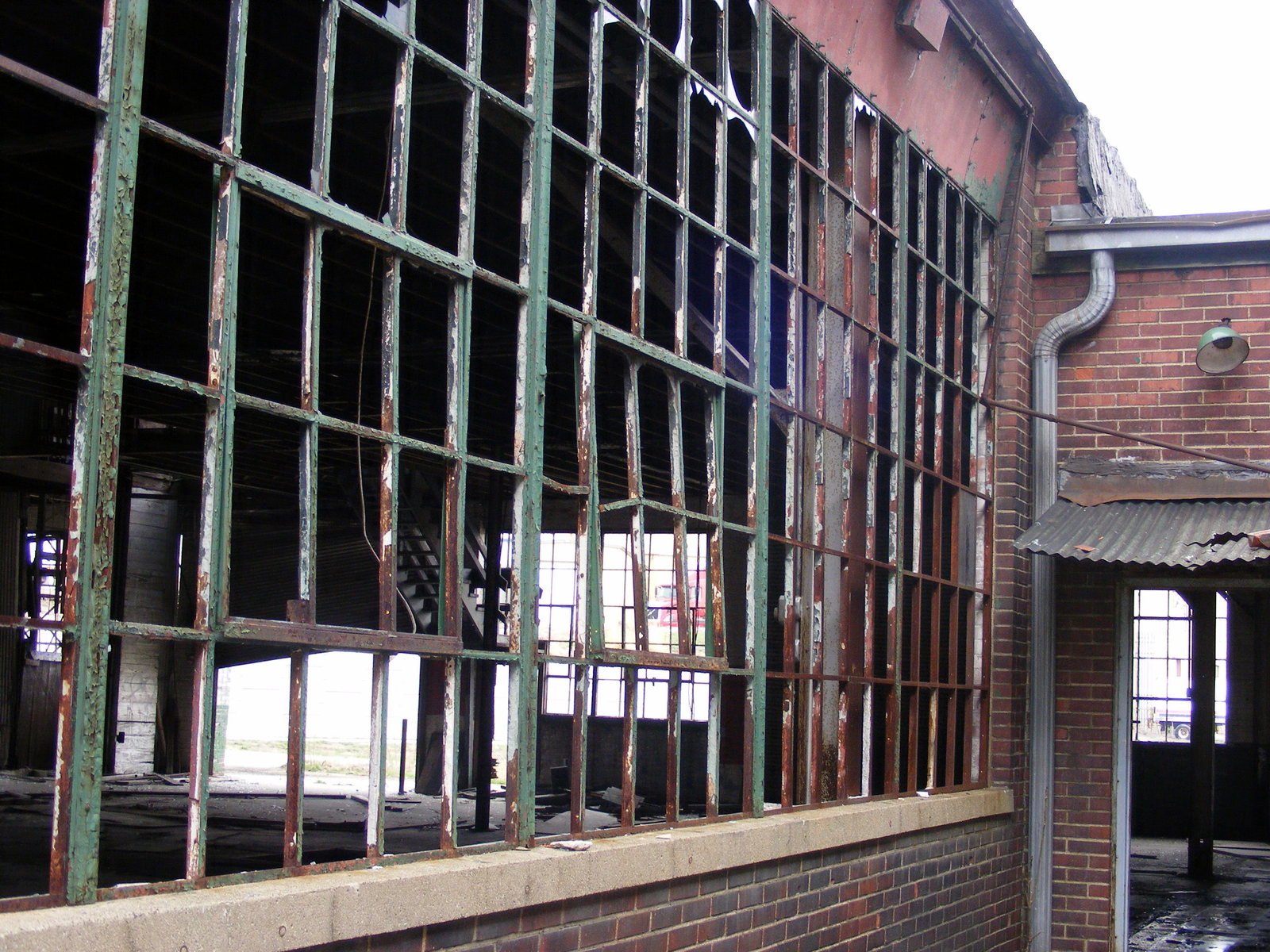 a building with rusted bars behind a metal gate