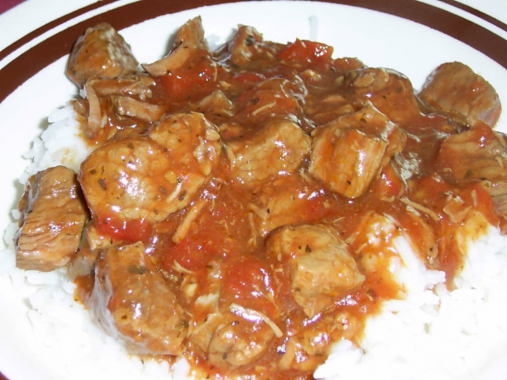 a white plate topped with meat covered in sauce