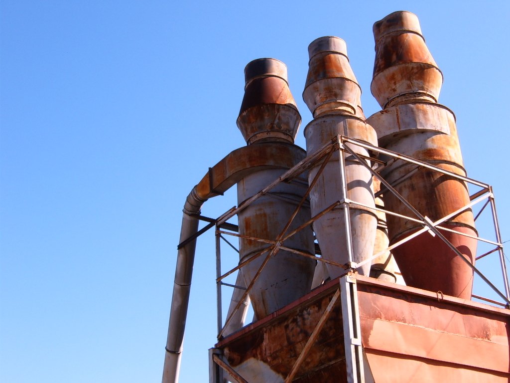 old rusty industrial pipes and rusted machinery against a blue sky