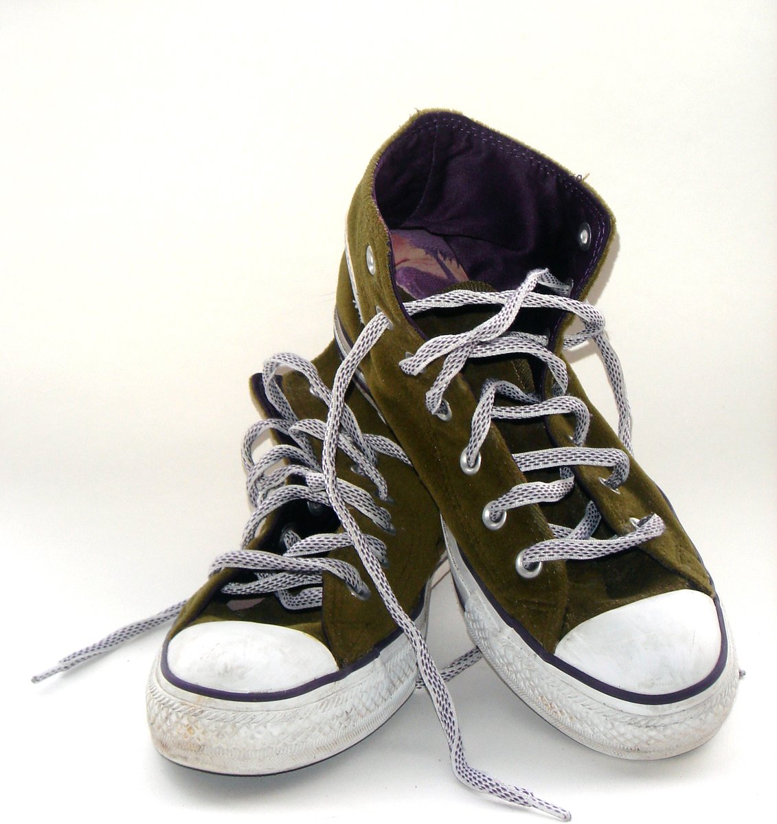 pair of sneakers with laces sitting on the ground