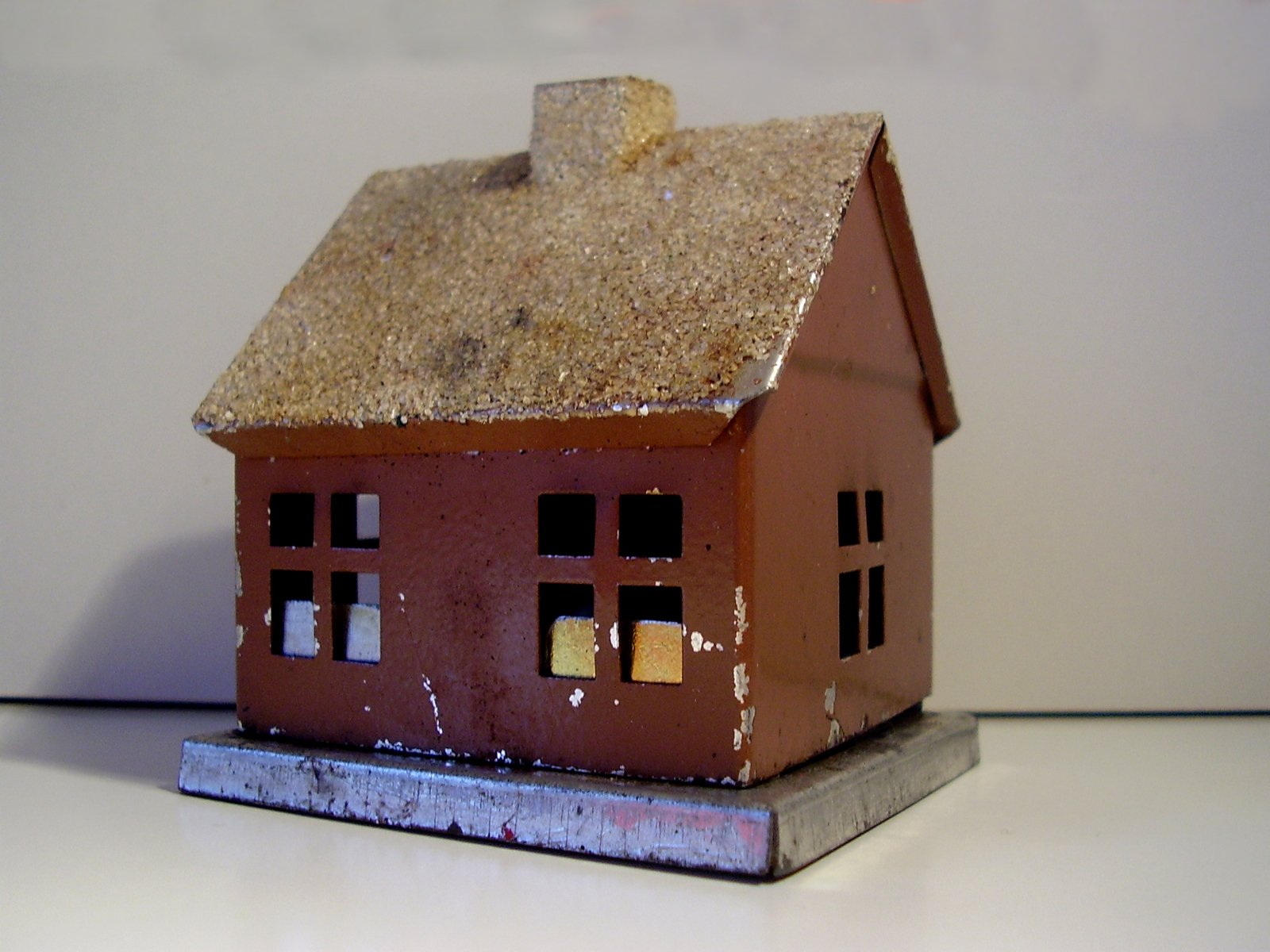 a miniature red clay house with windows and a roof