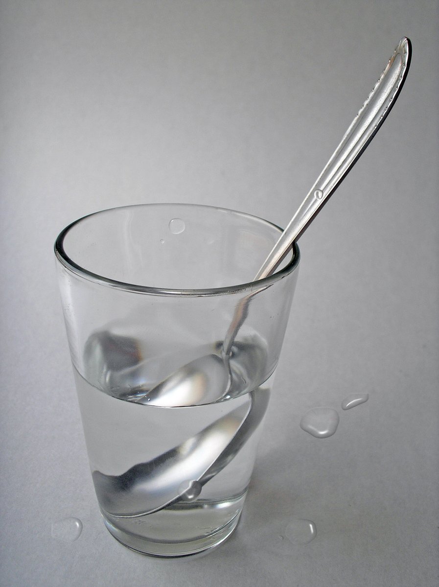 a small glass cup with two spoons in it