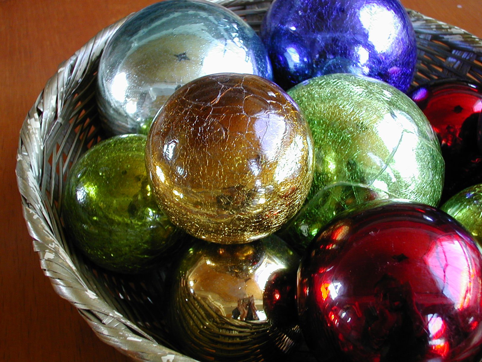 a basket filled with assorted shiny glass ornaments