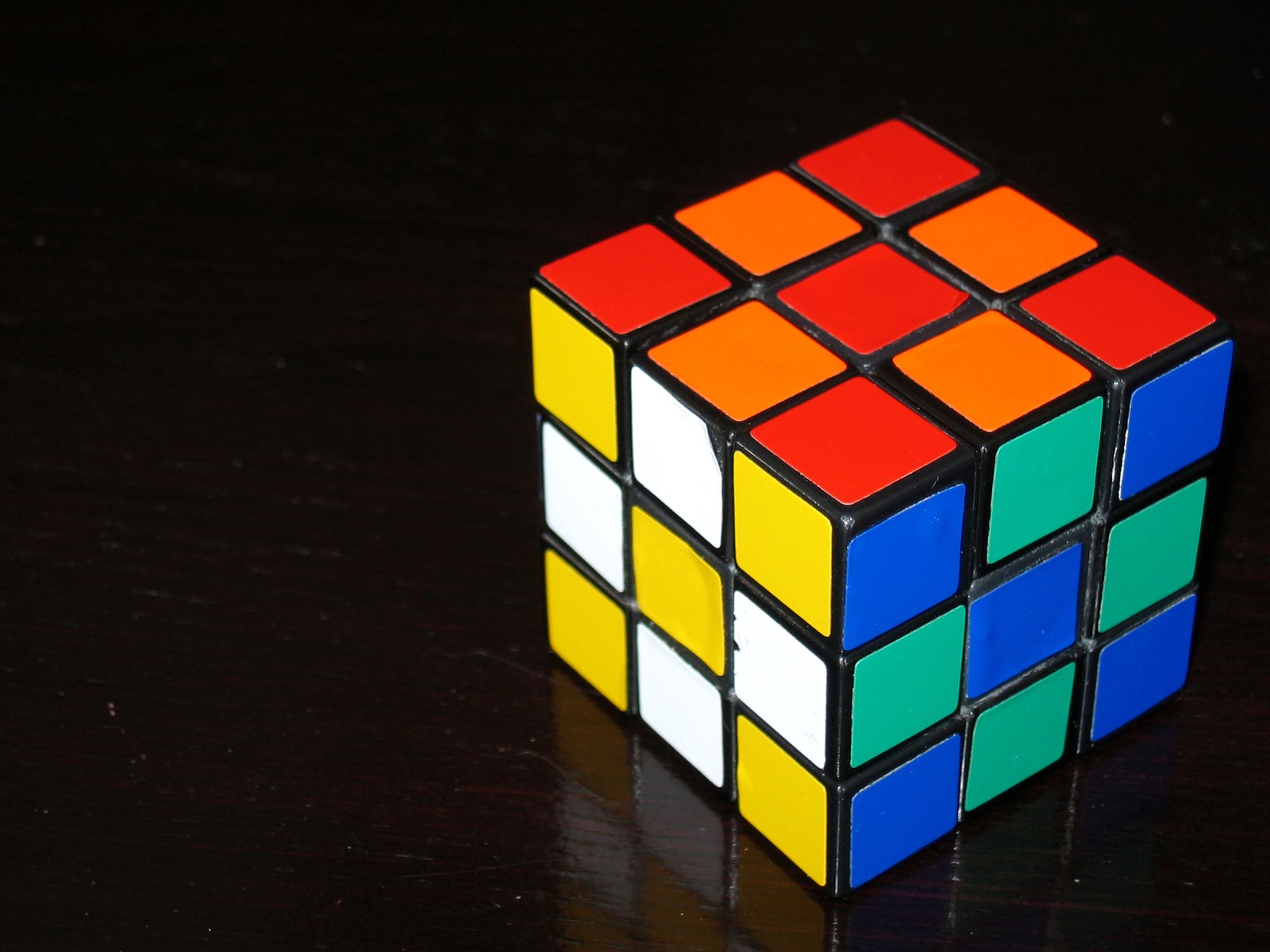 colorful cube on a black surface with one cube missing