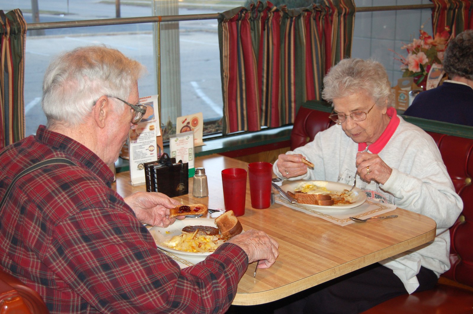 an old couple eats dinner together at a diner