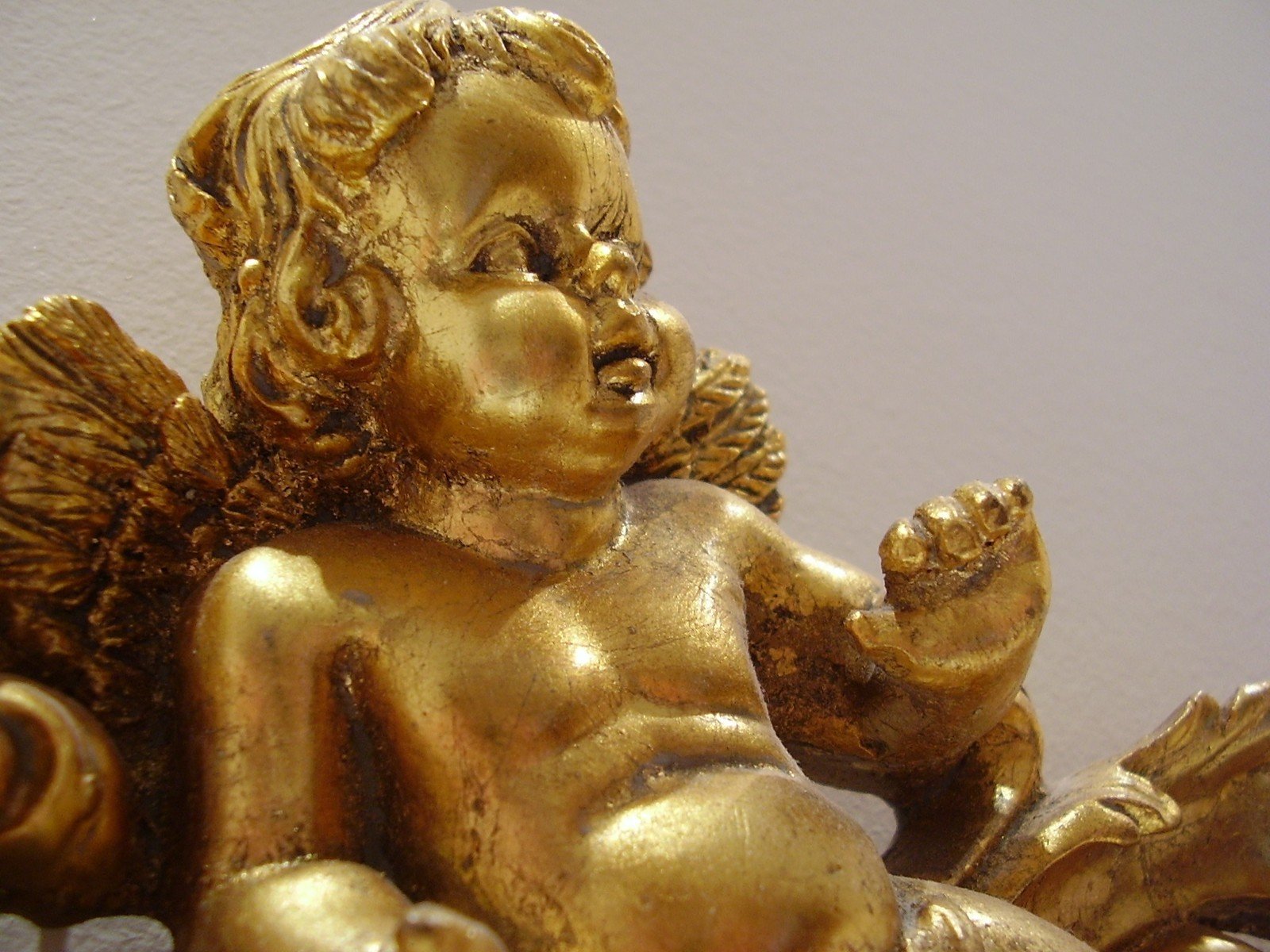 a golden statue of an infant sitting on its side