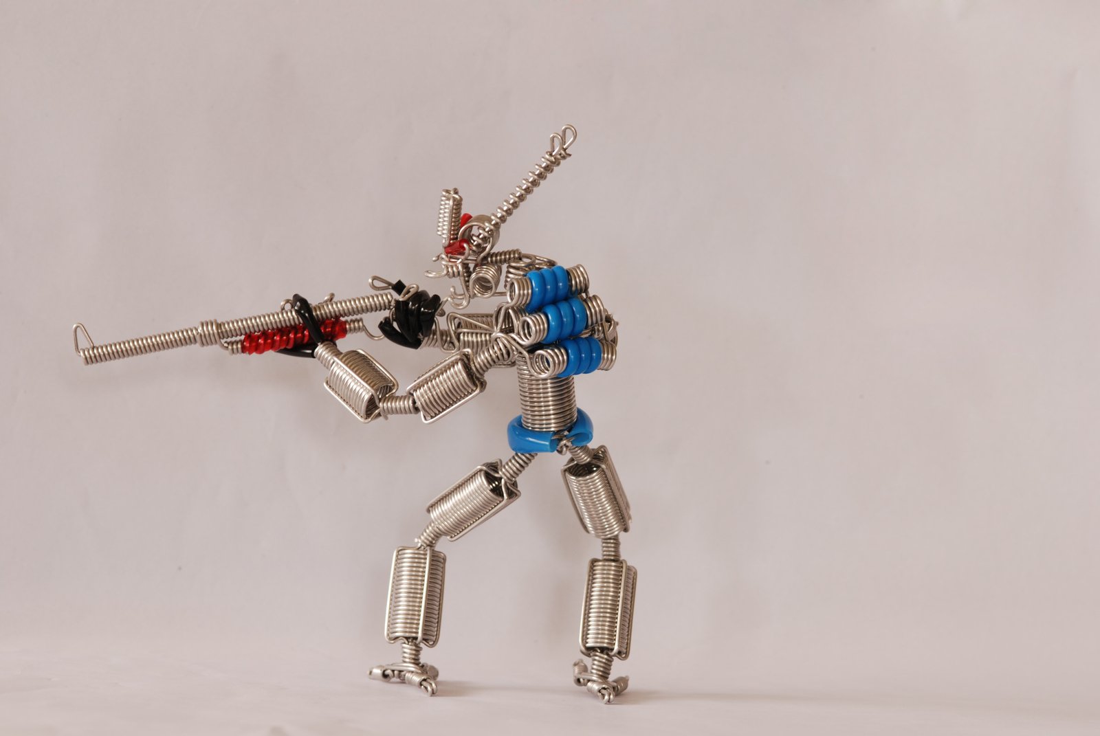 a silver robot with a gun on white background