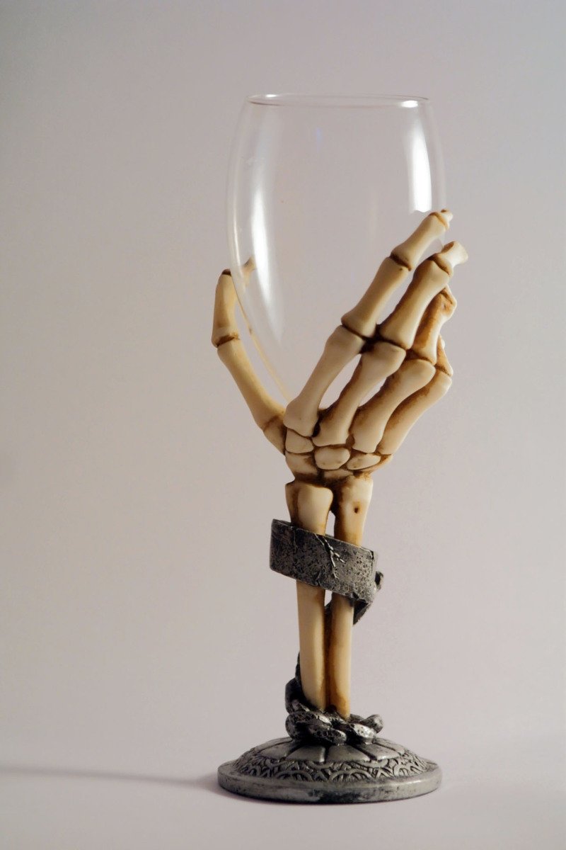 a hand with arms holding up a wine glass