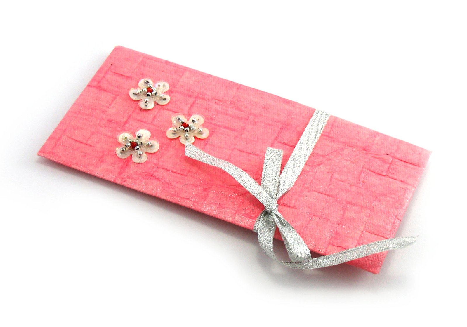 a pink wrapped gift with a silver ribbon and flowers on it