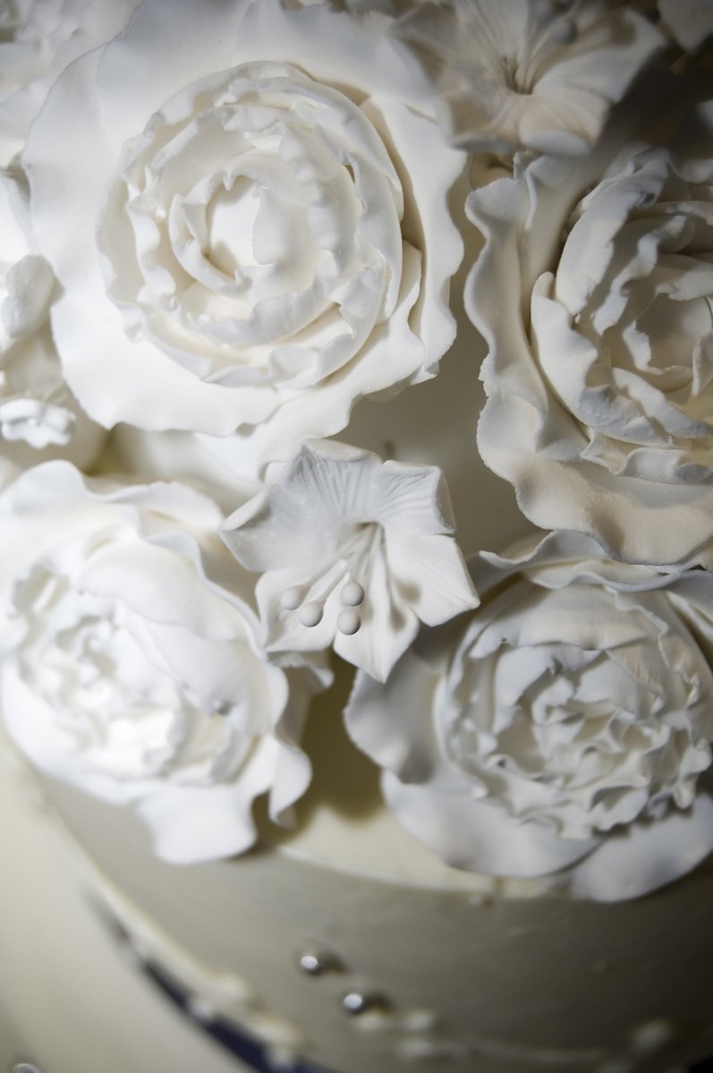 closeup of white icing flowers on top of cake