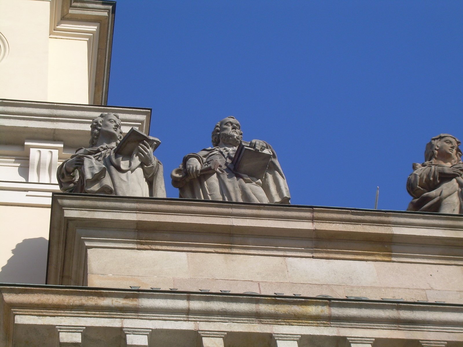 statues of men on a building on a clear day