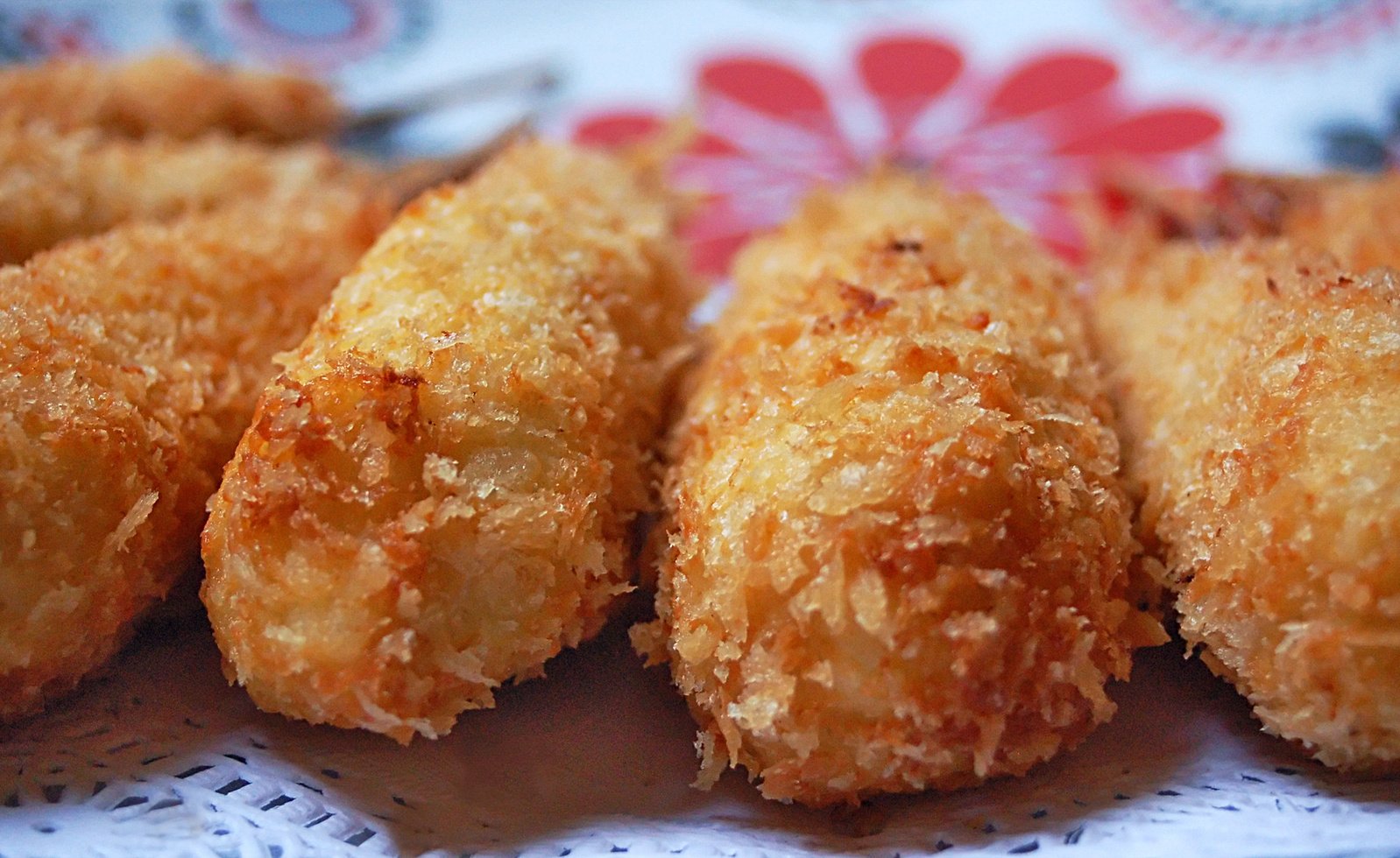 five fried food items sitting on top of a paper doily