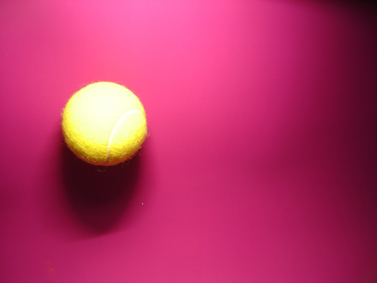 a tennis ball sitting on top of a pink table