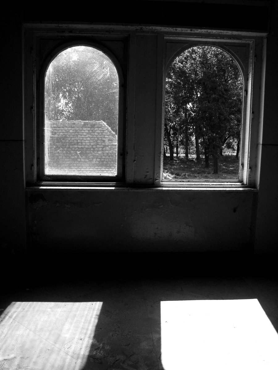 sunlight streaming through two arched windows onto the ground