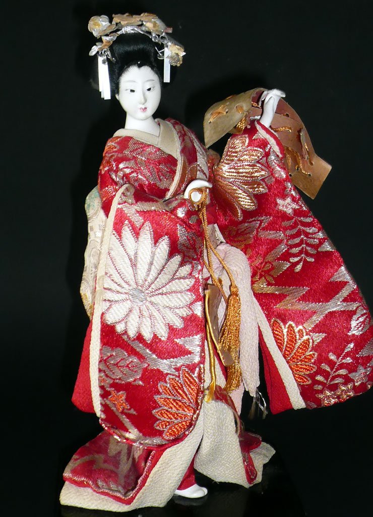 an asian doll with red and gold dress