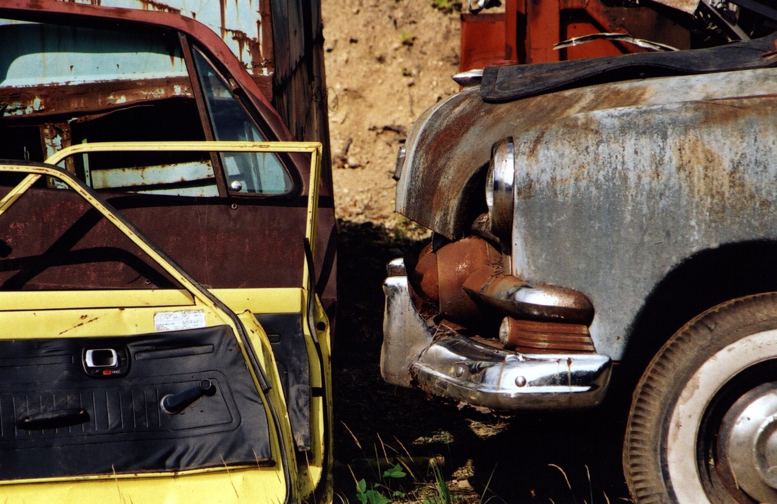 rusted out cars that are sitting in the dirt
