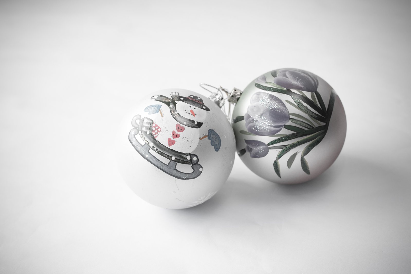 two ornaments sitting on top of a white surface