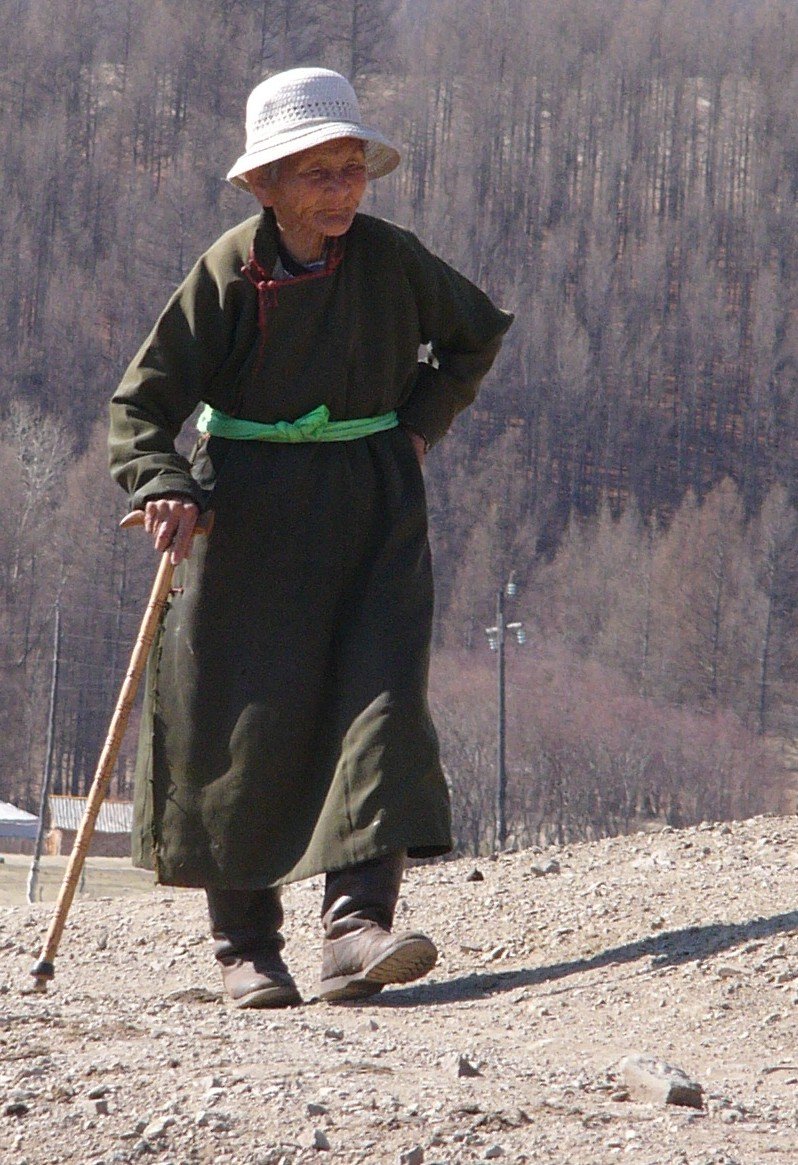an old man standing in the dirt with his stick