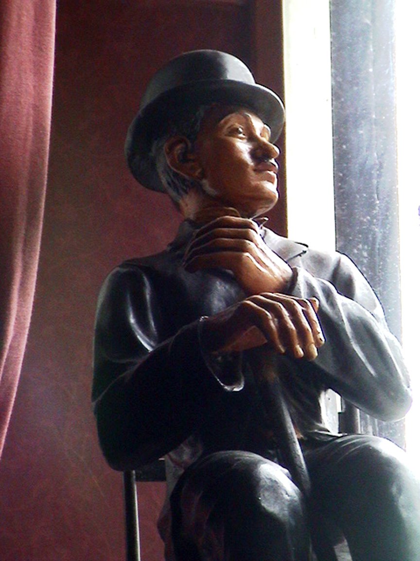 a statue is dressed in leather with a hat