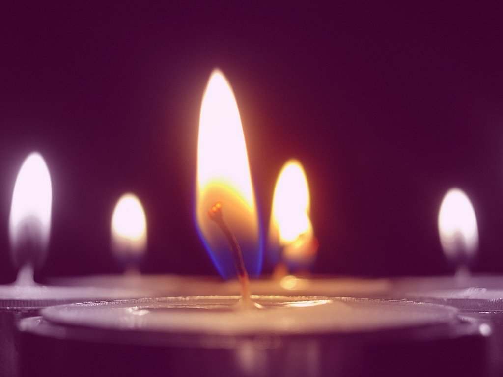 a couple of candles burning in a glass holder