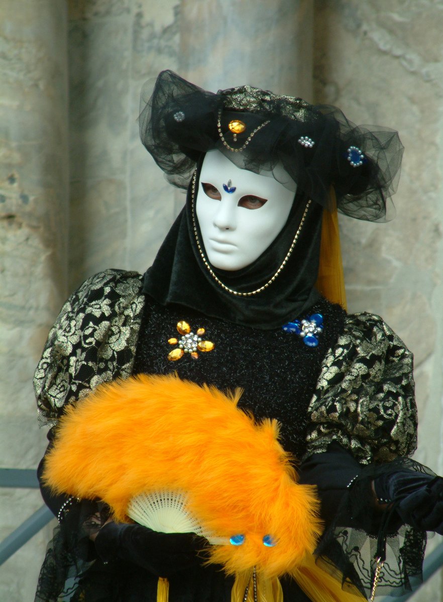 an artistic clown with yellow hair wearing black and gold clothes