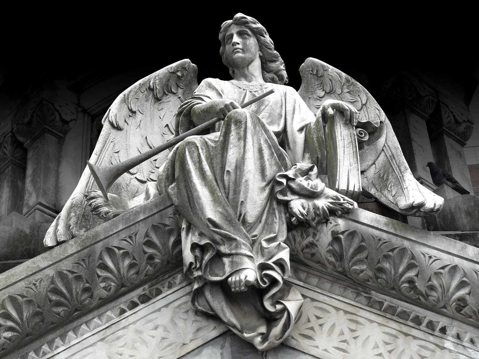 a statue of an angel sitting on top of a pillar