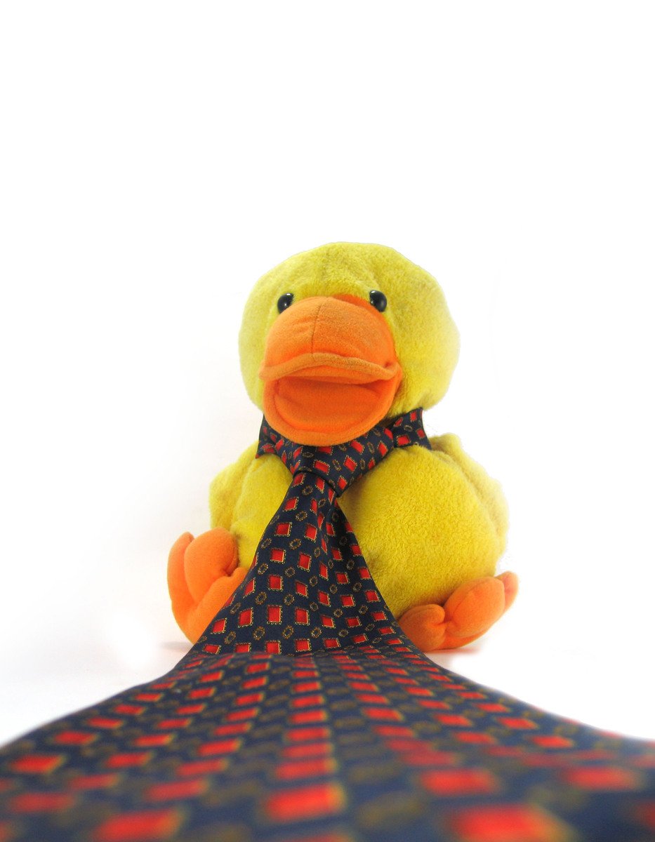 a duck toy sitting on top of a pillow