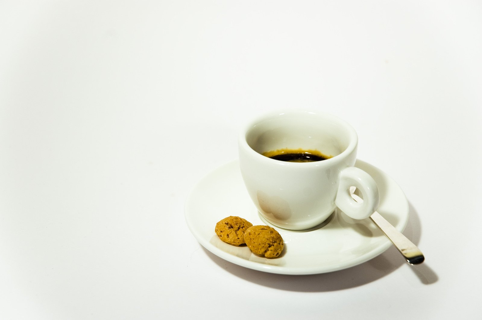 coffee cup with cookies on saucer with spoon