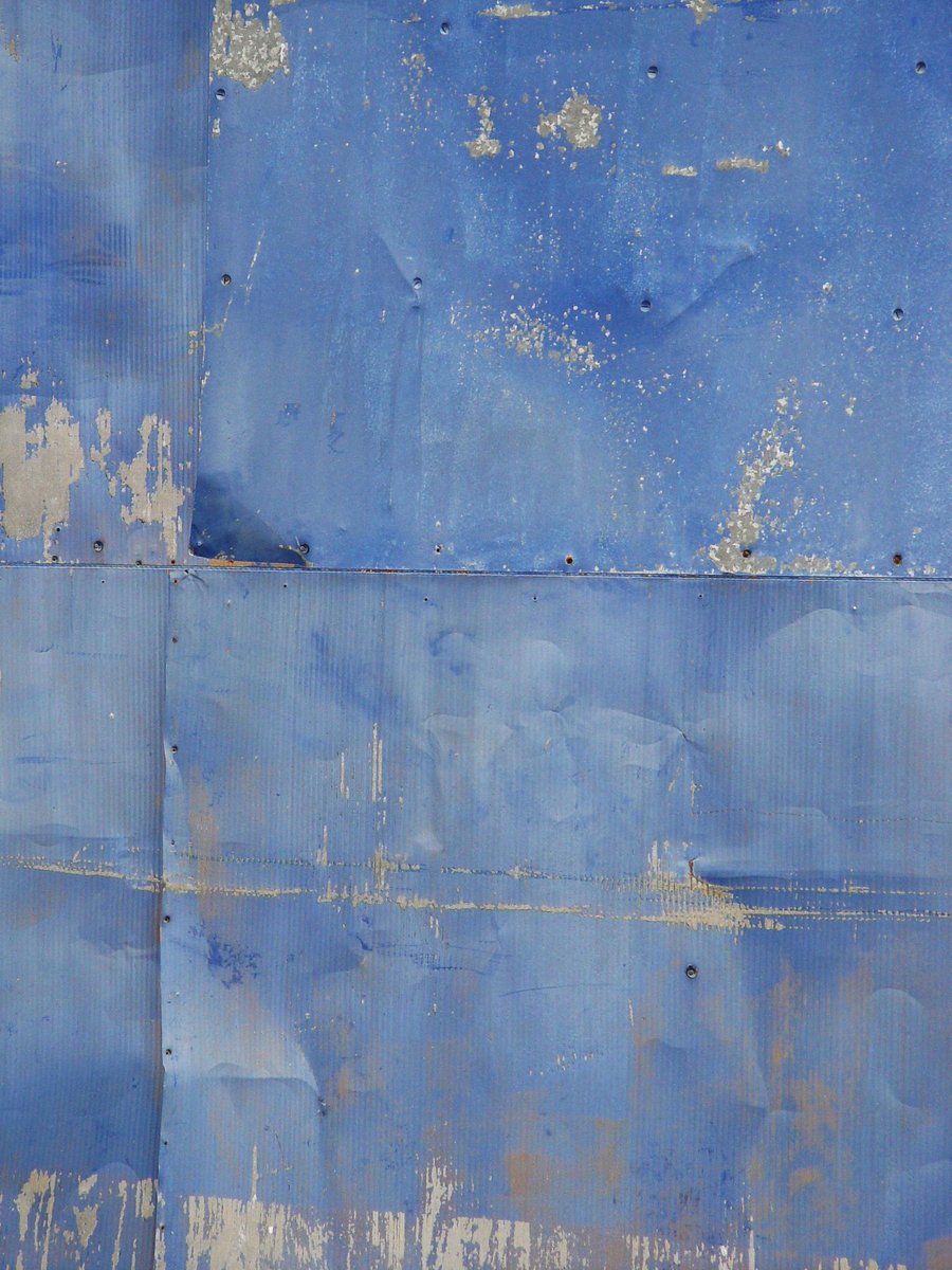 an orange umbrella rests on the floor against a blue wall