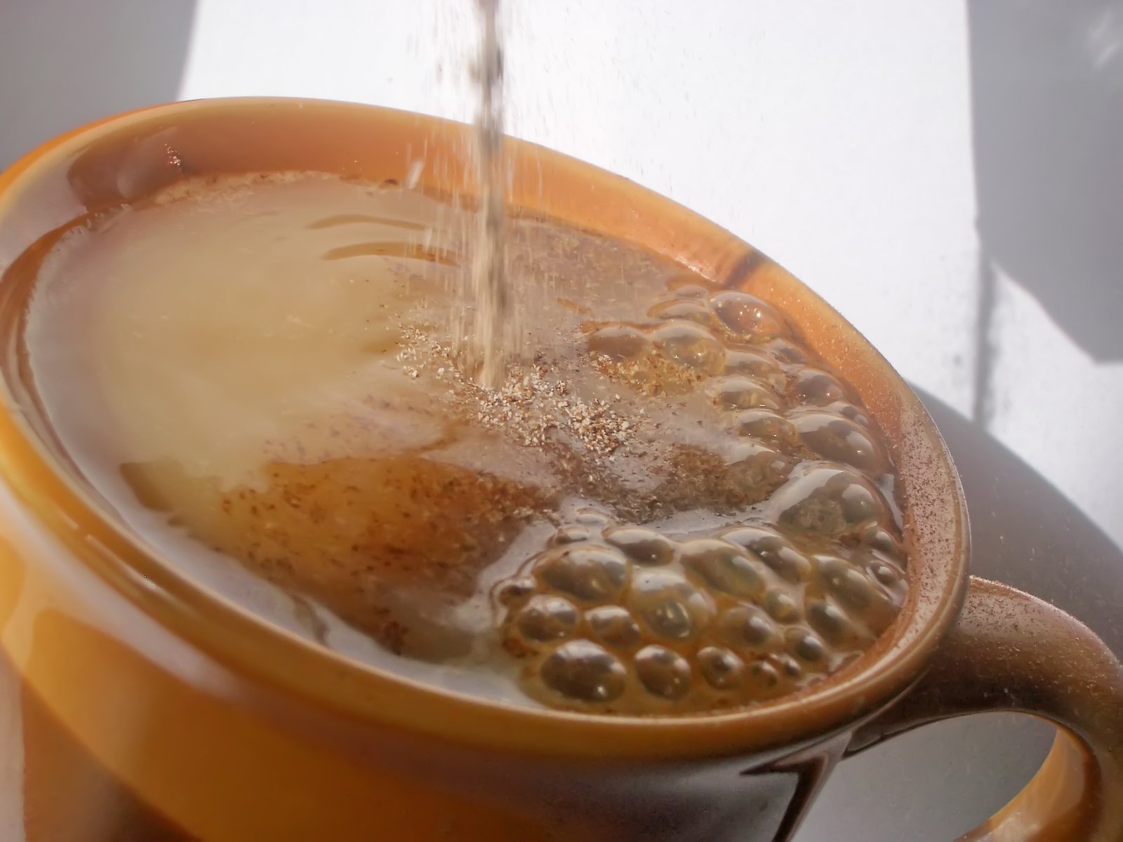 water is flowing from the faucet in a coffee mug